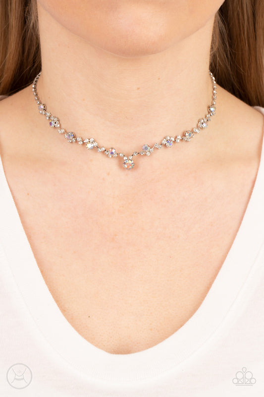 Regal Rebel Multi Choker Necklace - Paparazzi Accessories   Featuring pronged silver fittings, pairs and clusters of dainty white and iridescent rhinestones delicately connect to a strand of icy white rhinestones around the neck for a regal attitude. Features an adjustable clasp closure.  Sold as one individual choker necklace. Includes one pair of matching earrings.