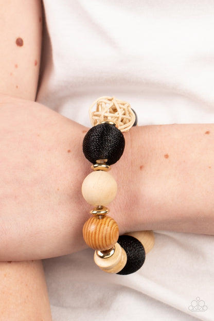 Happily Homespun Black Bracelet - Paparazzi Accessories  Infused with a single rattan sphere, a mismatched collection of oversized wooden beads, black thread wrapped beads, dainty gold accents, and glassy black beads are threaded along stretchy bands around the wrist for a homespun vibe.  Sold as one individual bracelet.