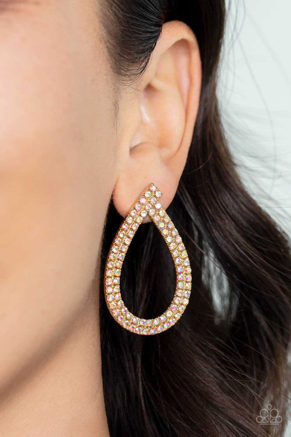 Diva Dust Gold Earring - Paparazzi Accessories  Glitzy ribbons of dainty iridescent rhinestones delicately swoop into a stellar teardrop frame, resulting in a sultry sparkle. Due to its prismatic palette, color may vary. Earring attaches to a standard post fitting.  Sold as one pair of post earrings.