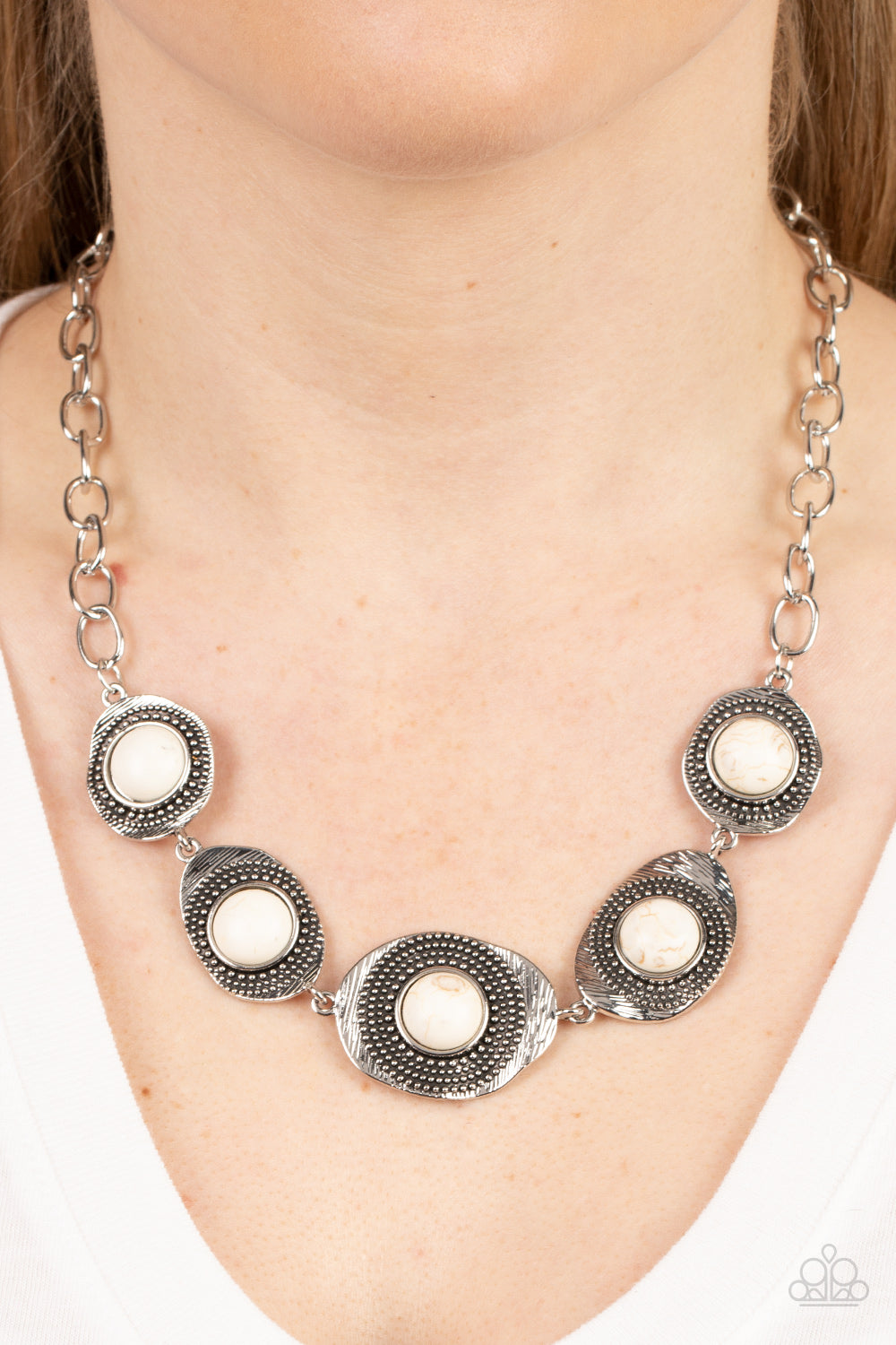 Homestead Harmony White Necklace - Paparazzi Accessories Item #P2SE-WTXX-282XX Refreshing white stones dot the centers of wavy irregular-shaped frames. Embellished with studded and etched feathery texture, the rustic frames create an earthy artisanal display below the collar. Features an adjustable clasp closure.  Sold as one individual necklace. Includes one pair of matching earrings.
