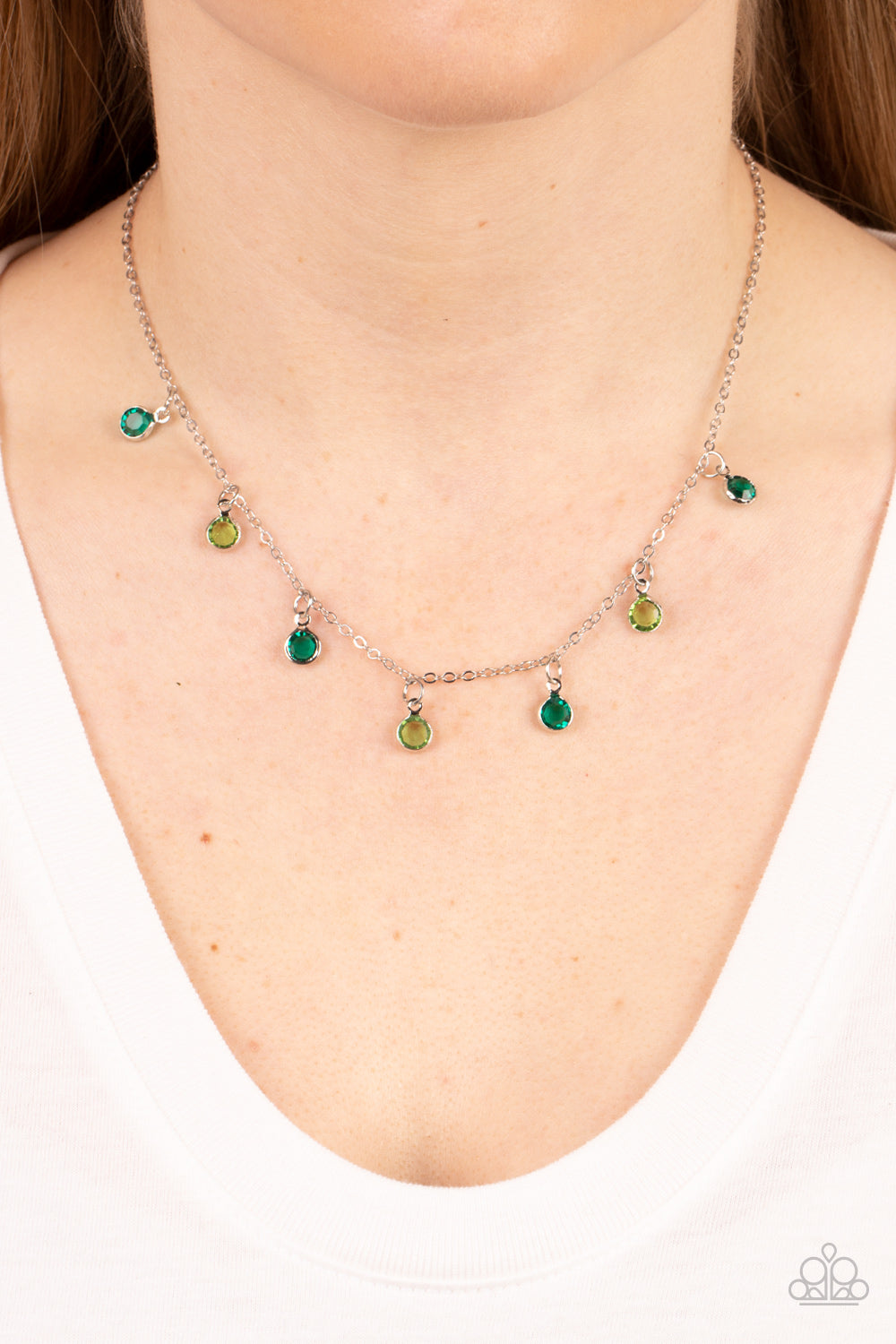 Carefree Charmer Green Necklace - Paparazzi Accessories  Encased in sleek silver fittings, a dainty collection of glassy green and light green gems twinkles along a dainty silver chain below the collar, creating a colorful fringe. Features an adjustable clasp closure.  Sold as one individual necklace. Includes one pair of matching earrings.