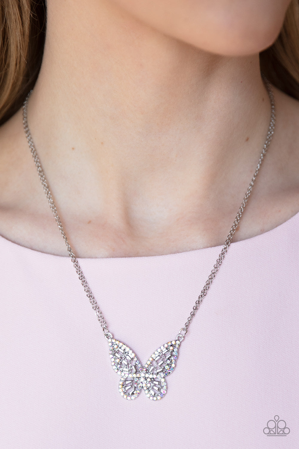 Baroque Butterfly Multi Necklace - Paparazzi Accessories  Bordered in iridescent rhinestones, an airy silver butterfly is dotted in dainty iridescent rhinestones and shiny silver emerald-like accents as it flutters from two chains below the collar for an enchanting fashion. Features an adjustable clasp closure. Due to its prismatic palette, color may vary.  Sold as one individual necklace. Includes one pair of matching earrings.  Get The Complete Look! Bracelet: "Butterfly Bella - Multi" (Sold Separately)