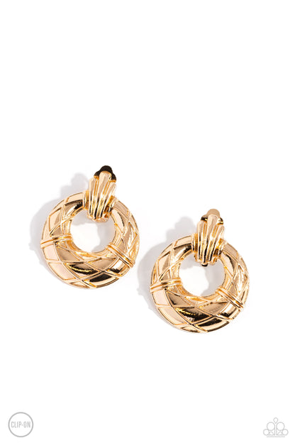 Metro Voyage Gold Clip-On Earring - Paparazzi Accessories  Faux gold wires wrap across the front of a curvy hoop at the bottom of a decorative gold fitting, resulting in an edgy refinement. Earring attaches to a standard clip-on fitting.  Sold as one pair of clip-on earrings.  P5CO-GDXX-078XX