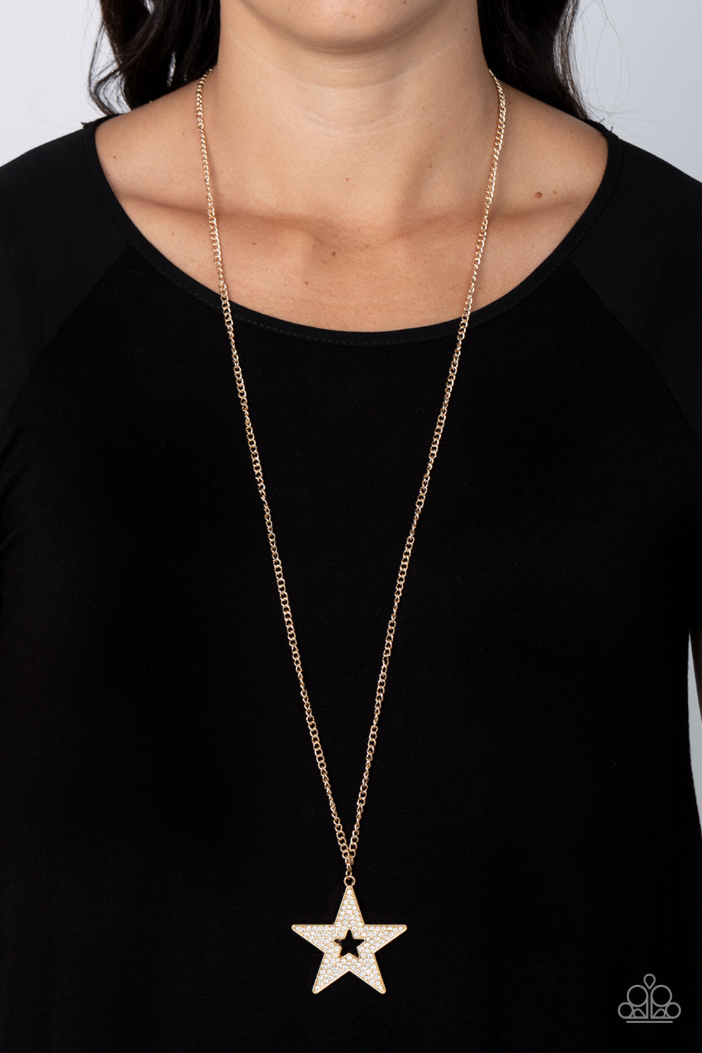 Superstar Stylist Gold Necklace - Paparazzi Accessories  Blinding white rhinestones are encrusted across the front of an oversized gold star frame at the bottom of a lengthened gold chain, resulting in a stellar sparkle. Features an adjustable clasp closure.  Sold as one individual necklace. Includes one pair of matching earrings.