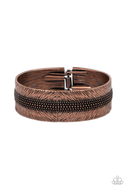 Rancho Refinement Copper Hinge Bracelet - Paparazzi Accessories  A thick band of copper is etched in feathery texture, creating a tactile statement piece that boldly wraps around the wrist. Rows of antiqued copper studs travel around the center of the thick copper band, adding eye-catching dimension and grit to the design. Features a hinged closure.  Sold as one individual bracelet.