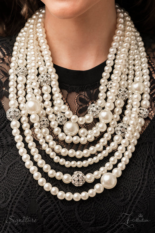 The Courtney 2022 Zi Collection Necklace - Paparazzi Accessories  Strand after strand of lustrous white pearls layer down the chest, creating timeless tiers. Airy silver spheres, adorned in sparkling white rhinestones, are effortlessly sprinkled among the sea of pearls, infusing the design with capricious shimmer, while larger pearl beads add dimension and depth to this classic motif. Features an adjustable clasp closure.  Sold as one individual necklace. Includes one pair of matching earrings.