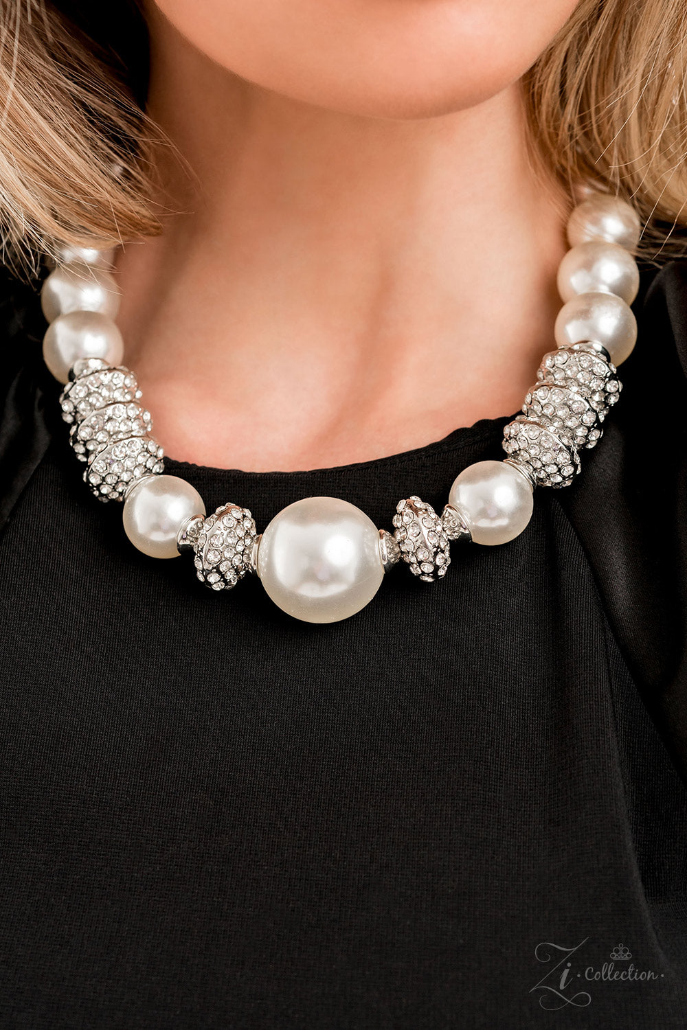 Noble 2022 Zi Collection Necklace - Paparazzi Accessories  Exaggerated white pearls gradually increase in size as they fall along the neckline, leading to a prominent centerpiece. The refined palette is complemented by shimmery silver accents, interspersed throughout the polished pearls and infused with sparkling rhinestones that scatter light in every direction. Features an adjustable clasp closure.