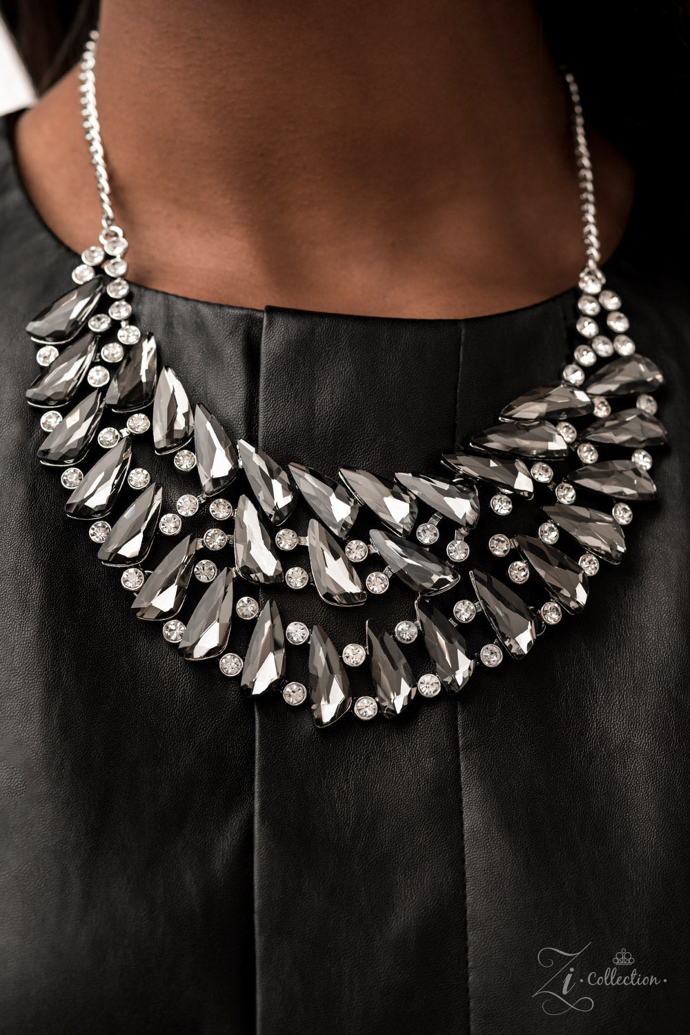Perceptive 2022 Zi Collection Necklace - Paparazzi Accessories  Smoky, triangular rhinestones are scattered along the collar in razor-sharp precision, falling into a dramatic, angular pattern. Brilliant white rhinestones are sprinkled in between the faceted, smoldering gems, adding fearless hints of sparkle to this glamorously gritty jaw-dropper. Features an adjustable clasp closure.
