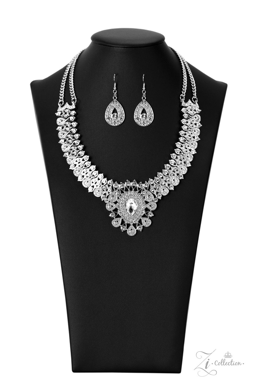 Silver, teardrop-shaped frames are stacked on-point below airy marquise cutouts, creating a subtle figure-eight. The hourglass shapes are threaded along invisible wires, falling into place alongside diamond-shaped frames, created by artfully aligned, smaller, teardrop silhouettes. Glittery rhinestones encrust the larger teardrop-shaped frames, with solitaire rhinestones dotting the others; the result is a blinding display of irresistible shimmer that leads to a heart-stopping centerpiece.