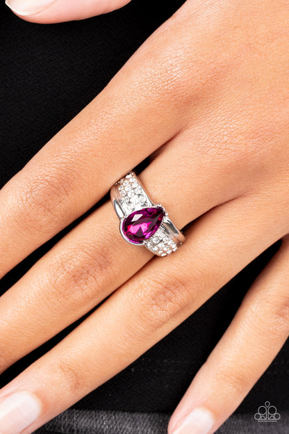 Dive into Oblivion Pink Ring - Paparazzi Accessories  Swathed in rows of dainty white rhinestones, an asymmetrical silver band is adorned with a bedazzling pink teardrop rhinestone for a regal finish. Features a dainty stretchy band for a flexible fit.  Sold as one individual ring.