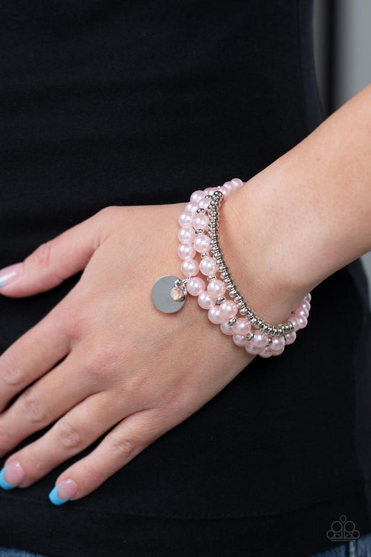 Pearly Professional Pink Bracelet - Paparazzi Accessories  Pink pearls, glistening silver beads, and an iridescent rhinestone are threaded along elastic stretchy bands, creating refined layers across the wrist.  Sold as one set of three bracelets.  P9RE-PKXX-300XX