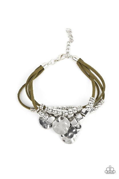 Token Trek Green Bracelet- Paparazzi Accessories   Asymmetrical, hammered silver discs swing from layers of Martini Olive suede that are adorned with silver discs, beads, and cubes, resulting in noisemaking shimmer around the wrist. Features an adjustable clasp closure.  Sold as one individual bracelet.