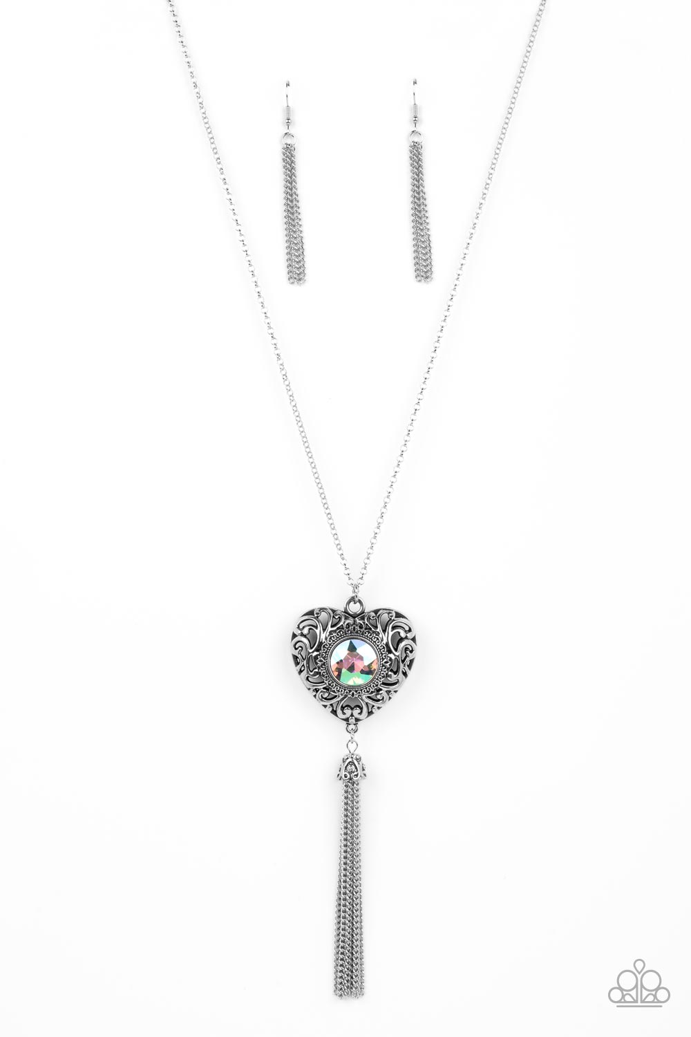 Prismatic Passion Green Necklace - Paparazzi Accessories  A magical iridescent green gem sparkles at the center of a 3-dimensional silver heart. Filled with vine-like filigree, the locket-inspired heart pendant glides along an extended silver chain while a shimmery tassel of silver chain dances from the bottom for a flirtatious finish. Features an adjustable clasp closure. Due to its prismatic palette, color may vary.  Sold as one individual necklace. Includes one pair of matching earrings.