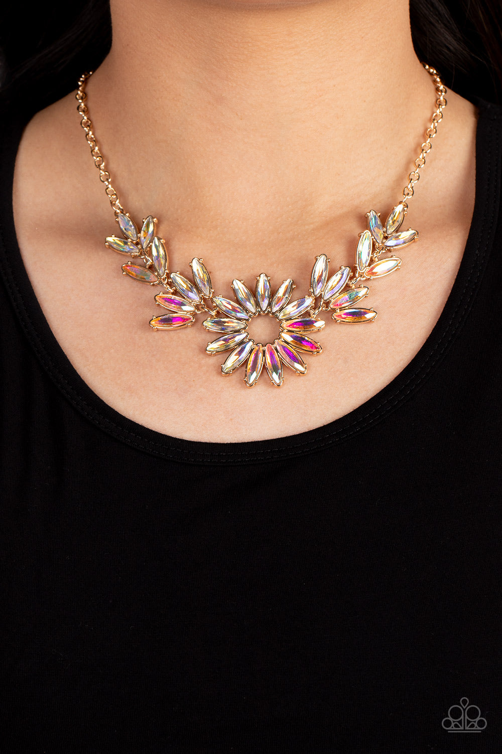 Celestial Cruise Gold Necklace - Paparazzi Accessories  Featuring oblong marquise cuts, a collection of iridescent gems join into leafy gold frames below the collar. Radiating with the same iridescent intensity, even more stellar rhinestones fan out into a circular focal point, resulting in a celestial centerpiece. Features an adjustable clasp closure. Due to its prismatic palette, color may vary.  Sold as one individual necklace. Includes one pair of matching earrings.