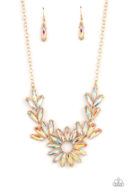 Celestial Cruise Gold Necklace - Paparazzi Accessories  Featuring oblong marquise cuts, a collection of iridescent gems join into leafy gold frames below the collar. Radiating with the same iridescent intensity, even more stellar rhinestones fan out into a circular focal point, resulting in a celestial centerpiece. Features an adjustable clasp closure. Due to its prismatic palette, color may vary.  Sold as one individual necklace. Includes one pair of matching earrings.