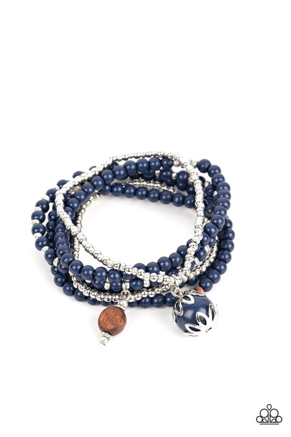 Epic Escapade Blue Bracelet - Paparazzi Accessories  A mismatched collection of silver, navy blue, and wooden beads are threaded along stretchy bands around the wrist. An ornate navy blue and wooden bead trickles from the layers, adding whimsical accents to the earthy display.  Sold as one set of six bracelets.  P9SE-BLXX-416XX