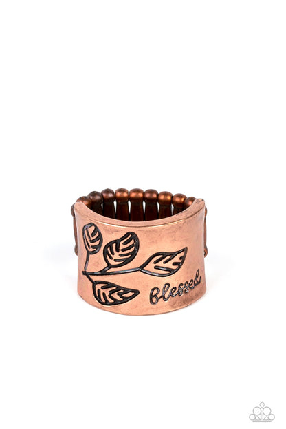 Blessed with Bling Copper Ring - Paparazzi Accessories  A thick band of copper is etched with a dainty leaf motif as the edges flare slightly to create a subtle curve. The word "blessed" is stamped at the bottom in an inspirational finish. Features a stretchy band for a flexible fit.  Sold as one individual ring.