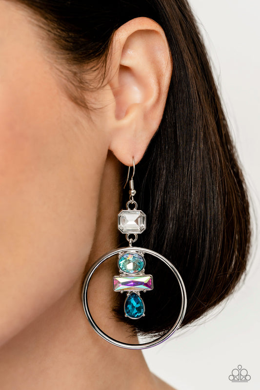 Geometric Glam Blue Earring - Paparazzi Accessories  Dangling from an asscher-cut white gem, a trio of blue and iridescent geometric-shaped gems glimmer inside airy silver hoops. Earring attaches to a standard fishhook fitting. Due to its prismatic palette, color may vary.  Sold as one pair of earrings.