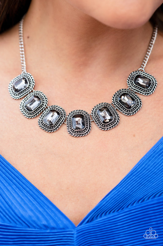Iced Iron Silver Necklace - Paparazzi Accessories  Pressed into silver, chain-like frames, radiant-cut hematite rhinestones smolder below the collar in a jaw-dropping finish. Features an adjustable clasp closure.  Sold as one individual necklace. Includes one pair of matching earrings.