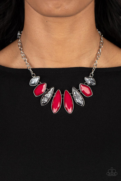 Crystallized Couture Red Necklace- Paparazzi Accessories  A thick silver chain gives way to a collection of edgy silver frames that fall in line along the collar. The asymmetrical frames are emphasized by the alternating gems inside them, resulting in a gorgeous palette of red and shimmery glitter. Features an adjustable clasp closure.  Sold as one individual necklace. Includes one pair of matching earrings.
