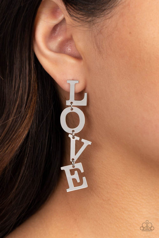 L-O-V-E Silver Post Earring - Paparazzi Accessories  Silver letters with a lightly hammered sheen spell out the word "LOVE" as they vertically cascade down the ear in a flattering finish. Each of the letters are interconnected to one another giving the piece some whimsically playful movement. Earring attaches to a standard post fitting.  Sold as one pair of post earrings.