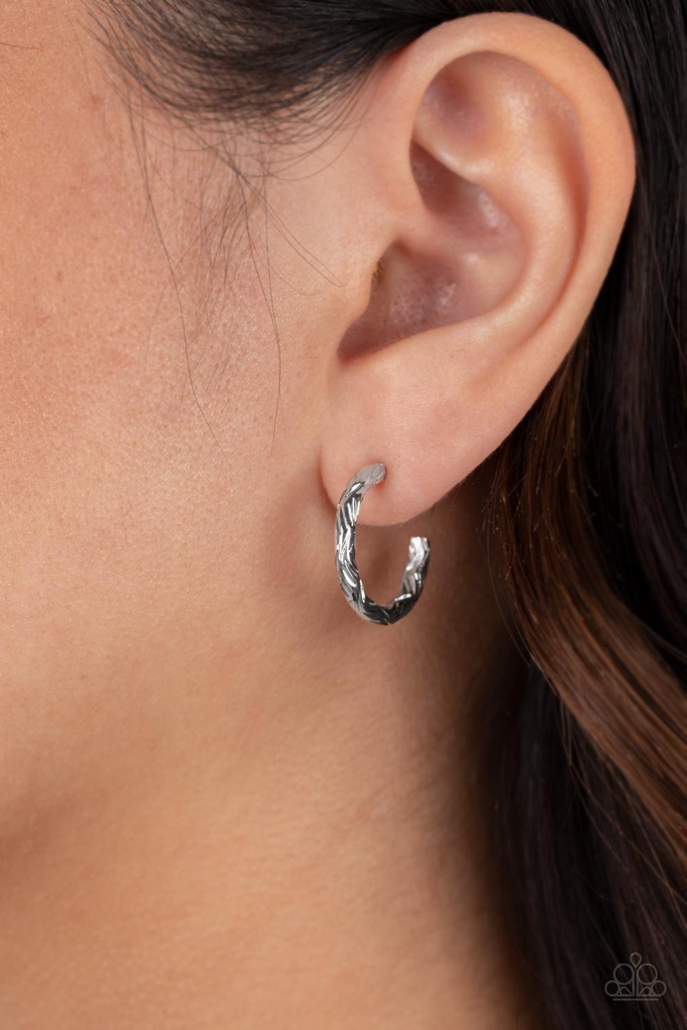 Triumphantly Textured Silver Hoop Earring - Paparazzi Accessories   A delicate band of silver is etched in linear textures, curling around the ear to create a small, classic hoop. Earring attaches to a standard post fitting. Hoop measures approximately 1/2" in diameter.  Sold as one pair of hoop earrings.
