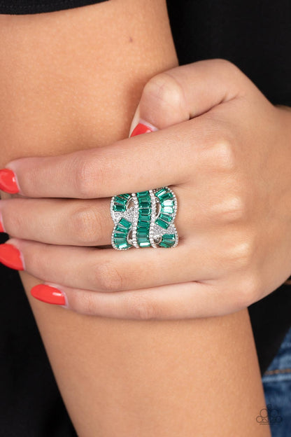 Six-Figure Flex Green Ring - Paparazzi Accessories  Rich green rhinestones, chiseled into dramatic emerald-cuts, fall in line along twisting bands of silver. Tiny white rhinestones border the top and bottom edges of the swirling silver bands, emphasizing the shimmer as they interlock across the top of the finger. Features a stretchy band for a flexible fit.  Sold as one individual ring.  P4ST-GRXX-017XX
