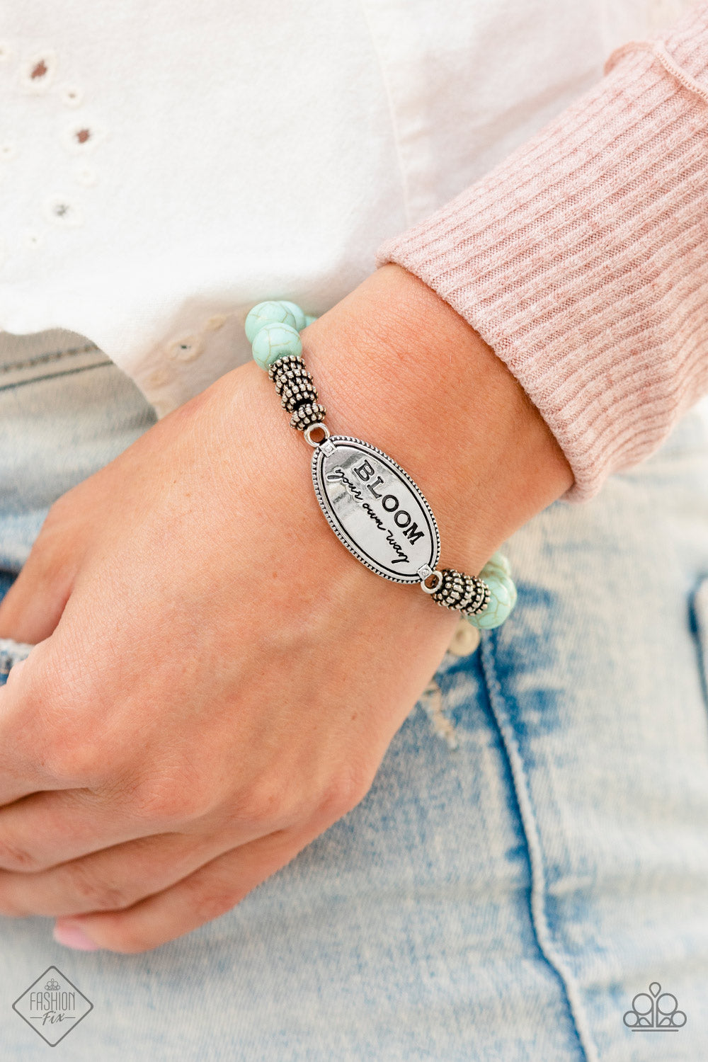 Bedouin Bloom Blue Bracelet - Paparazzi Accessories  An asymmetrical textured oval pendant features the phrase "BLOOM your own way" in a variety of fonts to emphasize the inspirational message. Four textured wheels fan out from the pendant to a refreshing collection of light blue stones that stretch along the wrist on an elastic stretchy band for a charming pop of color along the wrist. As the stone elements in this piece are natural, some color variation is normal.  Sold as one individual bracelet.