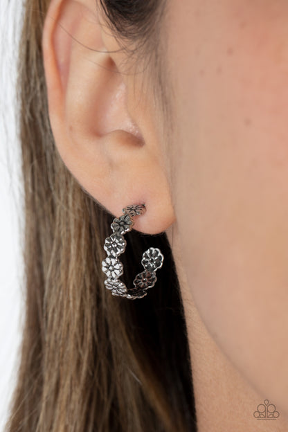 Floral Fad Silver Hoop Earring - Paparazzi Accessories  Tiny silver flowers connect to one another as they wrap around the ear to create a charming, dainty hoop. Earring attaches to a standard post fitting. Hoop measures approximately 3/4" in diameter.  Sold as one pair of hoop earrings.