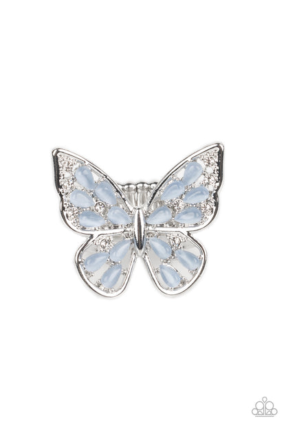 Flying Fashionista Blue Butterfly Ring - Paparazzi Accessories  Shiny silver bars curl into the shape of a butterfly, creating a whimsical centerpiece that flutters atop the finger. Blue opalescent beads fill the inside of the wings, leaving spaces in between for the design to remain airy and light. Finally, tiny white rhinestones line the inside edges of the silver frame, adding a hint of irresistible sparkle to the mix. Features a stretchy band for a flexible fit.  P4WH-BLXX-225XX