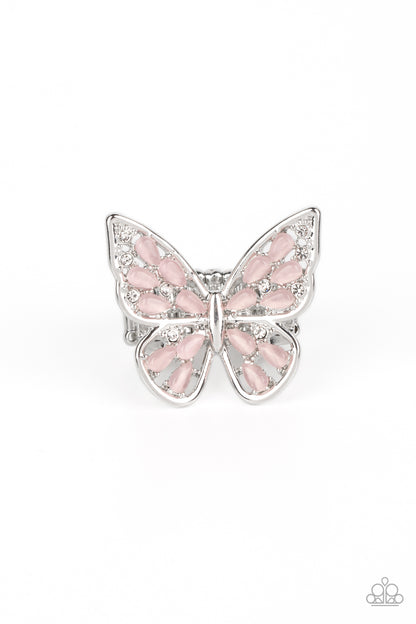 Flying Fashionista Pink Butterfly Ring - Paparazzi Accessories  Shiny silver bars curl into the shape of a butterfly, creating a whimsical centerpiece that flutters atop the finger. Pink opalescent beads fill the inside of the wings, leaving spaces in between for the design to remain airy and light. Finally, tiny white rhinestones line the inside edges of the silver frame, adding a hint of irresistible sparkle to the mix. Features a stretchy band for a flexible fit. P4WH-PKXX-248XX