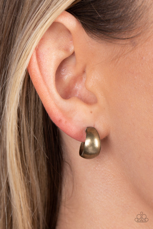 Burnished Beauty Brass Hoop Earring - Paparazzi Accessories  A thick bar of brass curls around the ear into a fashionable hoop. The dramatic curvature of the hoop is heightened by its high sheen finish, making a lasting impression. Earring attaches to a standard post fitting. Hoop measures approximately 1/2" in diameter.  Sold as one pair of hoop earrings.