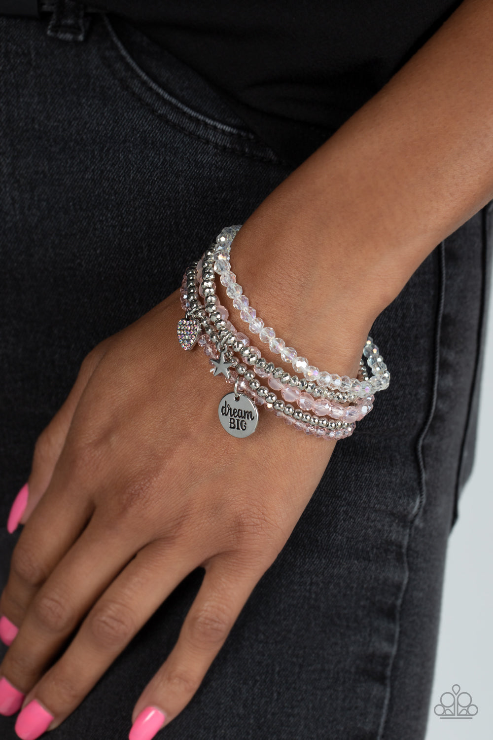 Teenage DREAMER Pink Bracelet - Paparazzi Accessories   Pink, silver, white, and smooth silver beads wrap around stretchy bands, and combine into a colorful stack along the wrist. The reflective, pink-beaded bracelet features a silver pendant with the phrase "dream BIG" stamped on it, while a silver-beaded bracelet features a silver star charm. Hanging from smooth, silver beads, a heart charm embossed with iridescent rhinestones adds a shimmery detail to the stack, resulting in a youthful, dreamy design.
