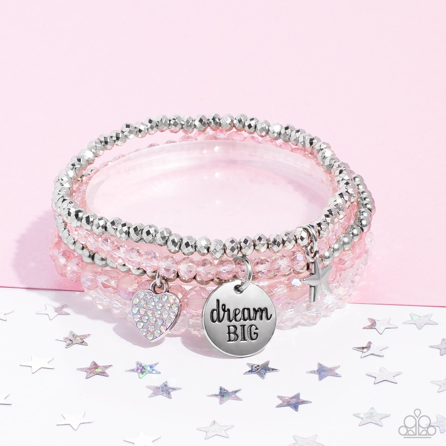 Teenage DREAMER Pink Bracelet - Paparazzi Accessories   Pink, silver, white, and smooth silver beads wrap around stretchy bands, and combine into a colorful stack along the wrist. The reflective, pink-beaded bracelet features a silver pendant with the phrase "dream BIG" stamped on it, while a silver-beaded bracelet features a silver star charm. Hanging from smooth, silver beads, a heart charm embossed with iridescent rhinestones adds a shimmery detail to the stack, resulting in a youthful, dreamy design.