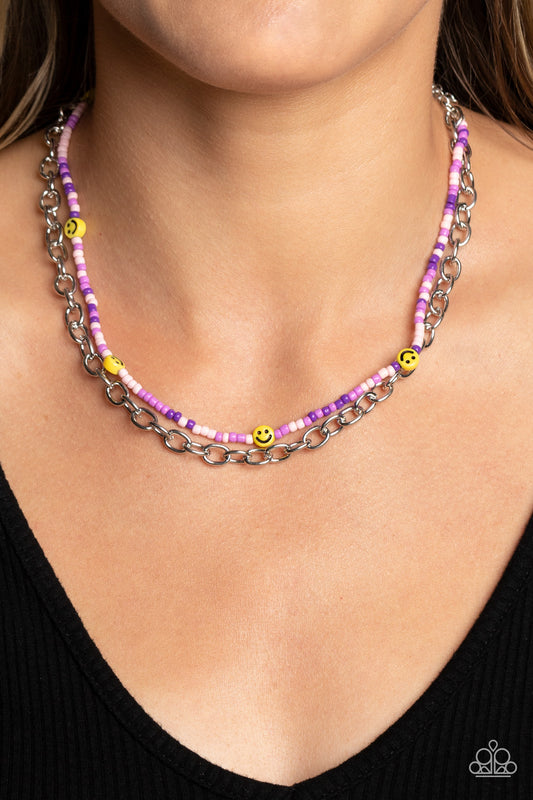 Happy Looks Good on You Purple Necklace - Paparazzi Accessories  Layered together with a bold silver chain, dainty purple, lavender, and baby pink seed beads are paired with yellow smiley face beads that thread along an invisible wire below the collar, resulting in a colorfully retro design. Features an adjustable clasp closure.  Sold as one individual necklace. Includes one pair of matching earrings.