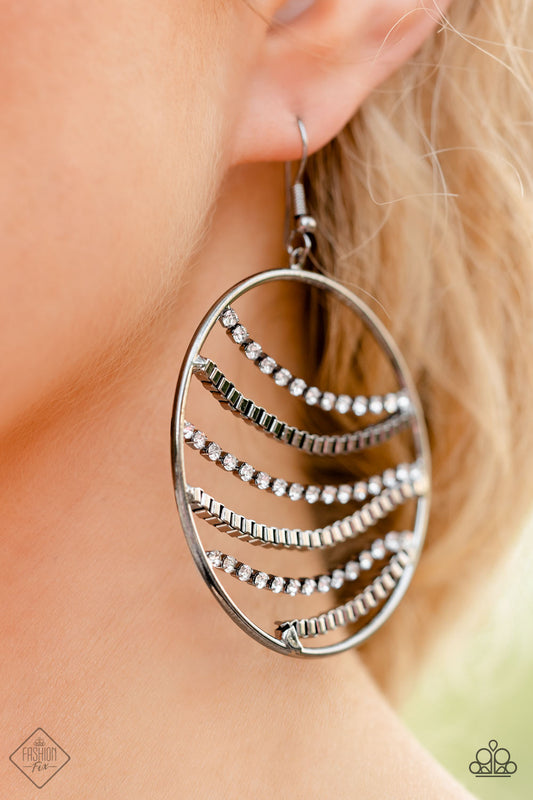 Fighting Fortune Black Earring - Paparazzi Accessories  Rippling across the inner circumference of an oversized gunmetal hoop, rows of glistening gunmetal box-chains, and dainty white rhinestones, pressed into square gunmetal frames glide into a sparkly, industrial palette below the ear. Earring attaches to a standard fishhook fitting.  Sold as one pair of earrings.