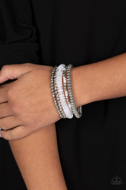 Pristine Pixie Dust White Bracelet - Paparazzi Accessories   Varying sizes and textures of silver beads combine with a collection of solid, milky, and cloudy white beads in varying sizes, to create a playful stack of bracelets that layer across elastic stretchy bands creating a youthful and energetic impression.  Sold as one set of five bracelets.