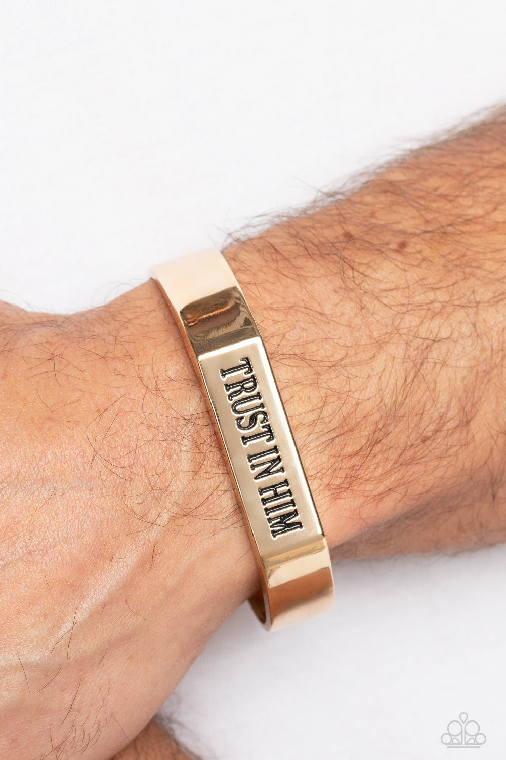 Trusting Trinket Gold Cuff Bracelet - Paparazzi Accessories  A thick, gold cuff coalesces into an edgy, urban statement across the wrist. Stamped on the center-most rectangular plate, the phrase "Trust in Him" boldly stands out for an inspirational finish.  Sold as one individual bracelet.