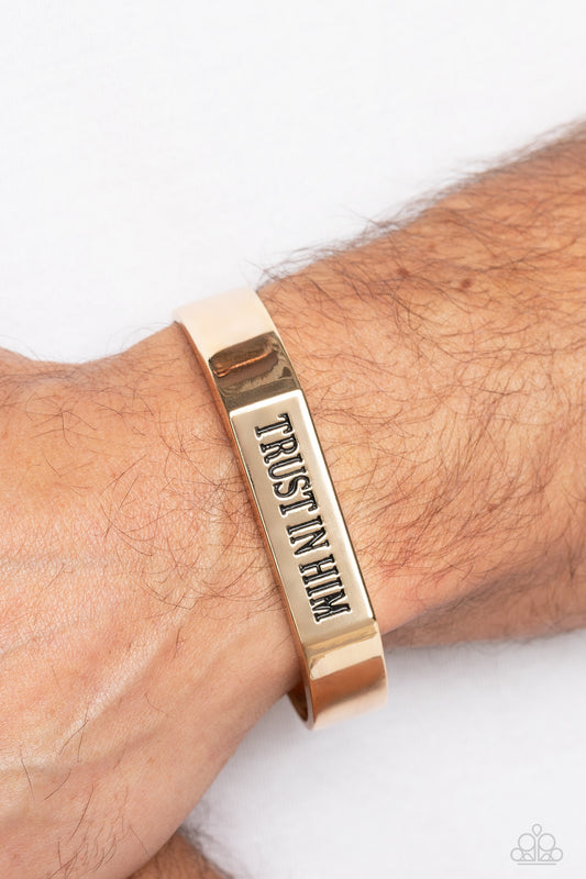 Trusting Trinket Gold Cuff Bracelet - Paparazzi Accessories  A thick, gold cuff coalesces into an edgy, urban statement across the wrist. Stamped on the center-most rectangular plate, the phrase "Trust in Him" boldly stands out for an inspirational finish.  Sold as one individual bracelet.
