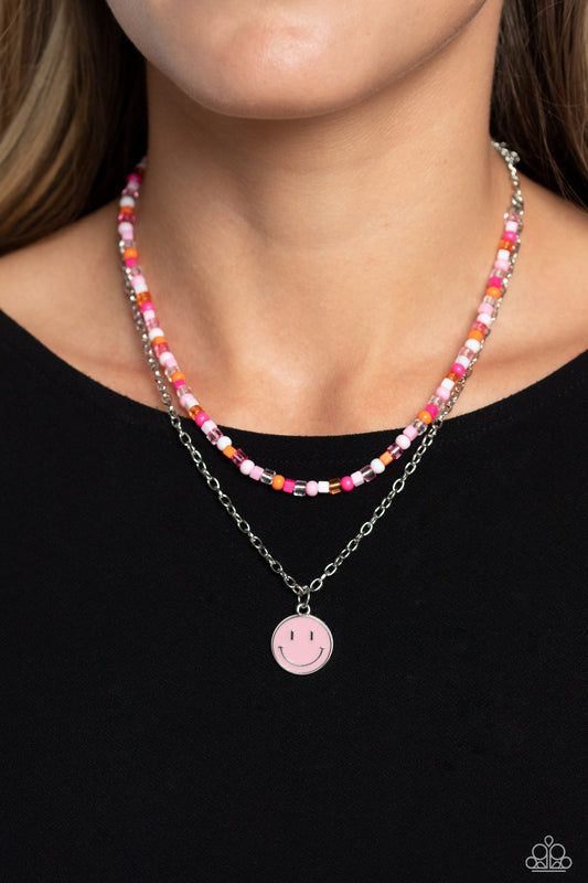 High School Reunion Pink Necklace - Paparazzi Accessories  Gliding from a dainty, silver chain, a smiley face pendant stands out against a pink backdrop. Completing the charismatic ensemble, a collection of seed beads in shades of light pink, white, pink, orange, and hot pink create bright pops of color around the neckline for a youthful finish. Features an adjustable clasp closure.  Sold as one individual necklace. Includes one pair of matching earrings.  P2SE-PKXX-248XX