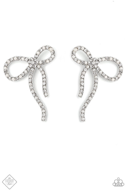 Deluxe Duet White Rhinestone Bow Earring - Paparazzi Accessories  Adorned in sparkling white rhinestones and dainty white pearls, a high-sheen band of silver curls and loops into a stunning bow, creating a charming lure. Featured in the center of the classy design, a dainty white rhinestone flower adds a floral finish to the stunning display. Earring attaches to a standard post fitting.  Sold as one pair of post earrings.