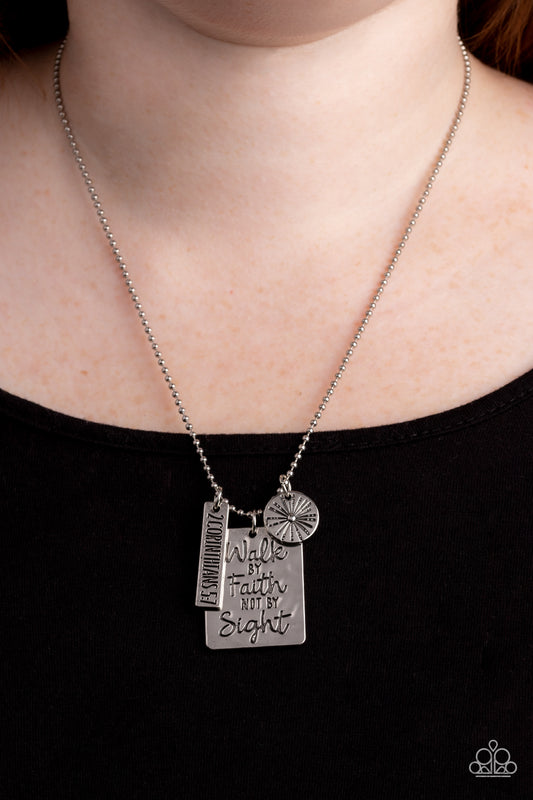 Hanging from a silver ball chain, a hammered collection of a rectangular plate dangles next to a disc featuring a sun, and a bar stamped with the Bible reference "2 Corinthians 5:7". The three dangling silver shapes add eye-catching movement to the inspired design. Prominently stamped on the rectangular pendant, the words "Walk by Faith not by Sight" stand out for a faith-filled finish. Features an adjustable clasp closure.  Sold as one individual necklace. Includes one pair of matching earrings.