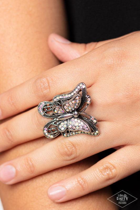 Free To Fly Multi Butterfly Ring - Paparazzi Accessories  Dazzling iridescent rhinestones are sprinkled across the wings of a silver butterfly, creating a whimsical frame atop the finger. Features a stretchy band for a flexible fit. Due to its prismatic palette, color may vary.  Sold as one individual ring.  P4RE-MTXX-048XX