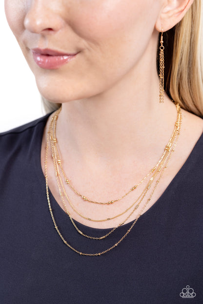Studded Shimmer Gold Necklace - Paparazzi Accessories  Multiple layers of dainty gold chains coalesce down the neck into a monochromatic mashup. Gold accents and dainty gold beads are infused throughout the chains for additional shimmer. Features an adjustable clasp closure.  Sold as one individual necklace. Includes one pair of matching earrings.  Sku:  P2DA-GDXX-308XX
