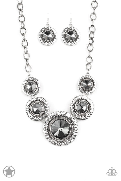 Global Glamour Silver Blockbuster Necklace - Paparazzi Accessories Gradually increasing in size, dramatically oversized smoky gems are pressed into the centers of hammered and silver studded frames. The blinding frames link below the collar for a glamorous, statement-making finish. Features an adjustable clasp closure.   Sold as one individual necklace. Includes one pair of matching earrings.