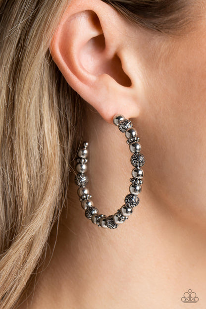 Rebuilt Ruins Silver Hoop Earring - Paparazzi Accessories  A collection of antiqued and decorative silver beads, silver wheel beads, and high-sheen silver beads are threaded along a thin curve around the ear for a trendy monochromatic look. Earring attaches to a standard post fitting. Hoop measures approximately 2" in diameter.  Sold as one pair of hoop earrings.  P5HO-SVXX-364XX