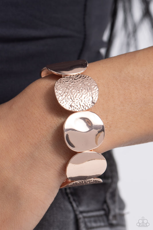 Rippling Record Rose Gold Stretch Bracelet - Paparazzi Accessories  A hammered collection of asymmetrical rose gold discs are threaded along stretchy bands around the wrist for a refined flair. The rose gold discs feature both a rippling hammered effect and a more subtle hammered effect, creating a fashionable contrast amidst the same color.  Sold as one individual bracelet.  Sku:  P9BA-GDRS-121XX