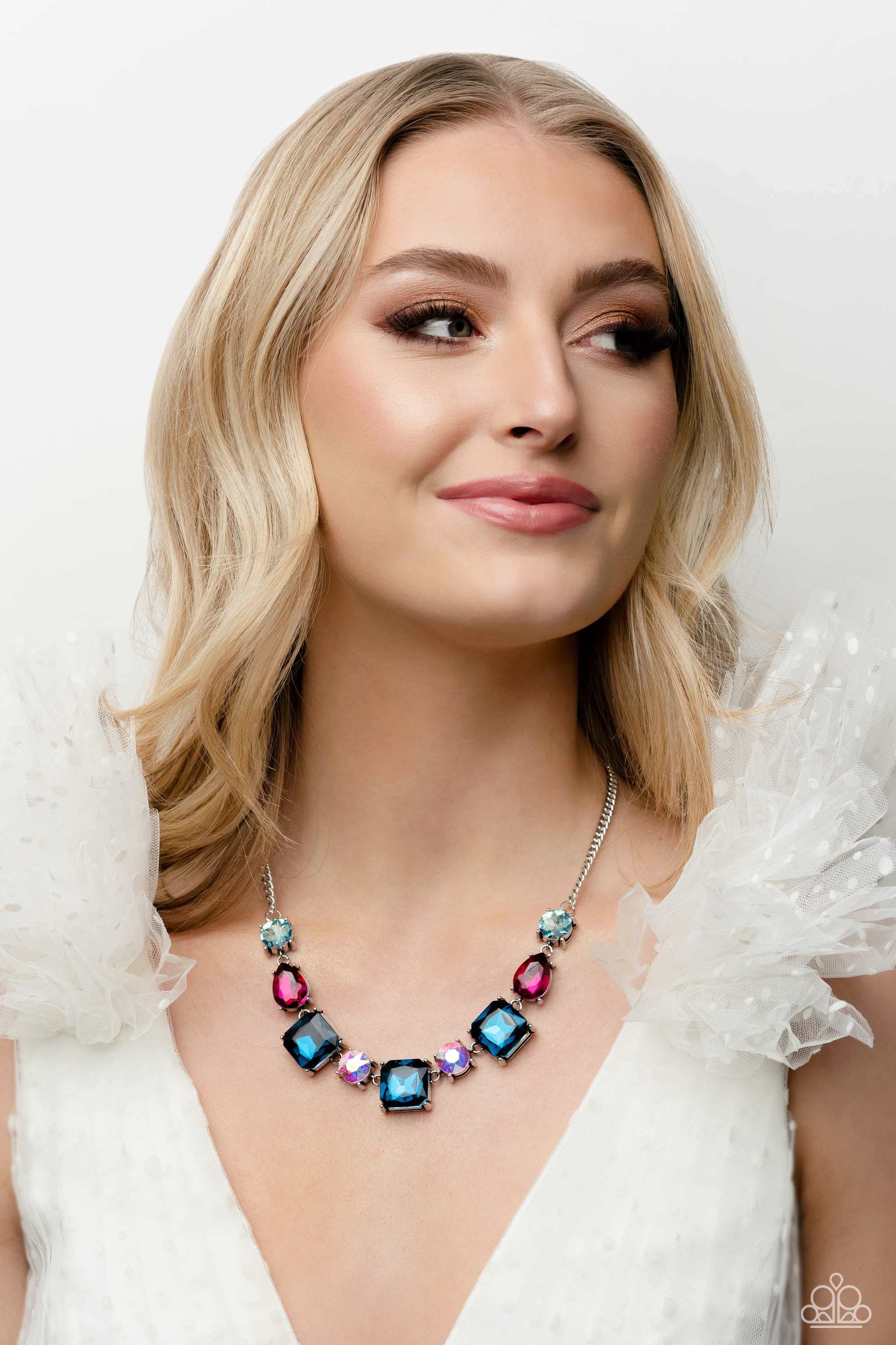 ﻿Elevated Edge Multi Necklace - Paparazzi Accessories  Encased within thick, pronged, elevated silver settings, a geometric collection of fuchsia, light blue, dark blue, and iridescent rhinestones, featured in square, teardrop, and round shapes coalesces down the neckline for a gritty, yet glamorous display. Features an adjustable clasp closure. Due to its prismatic palette, color may vary.  Sold as one individual necklace. Includes one pair of matching earrings.  P2RE-MTXX-215XX
