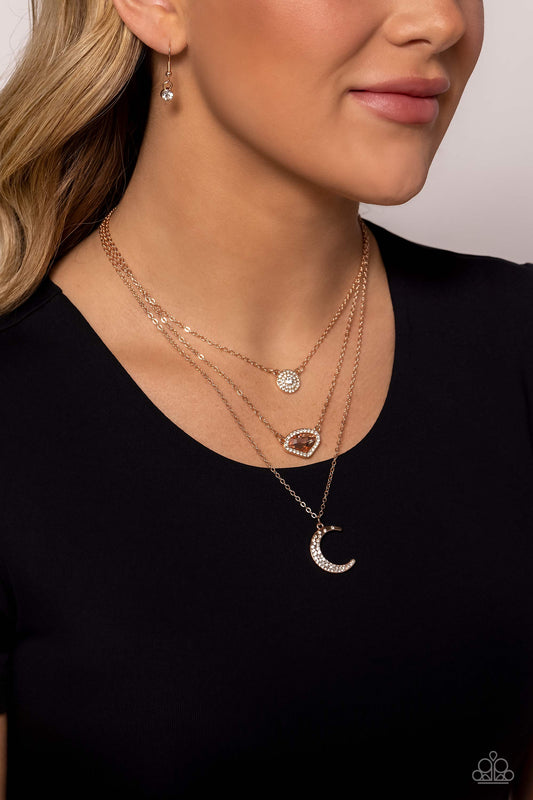 Lunar Lineup Rose Gold Necklace - Paparazzi Accessories  Three shimmery rose gold chains, infused with three stellar pendants, layer across the chest in a celestial display. A dainty, white rhinestone-encrusted, rose gold pendant with a white center swings from the uppermost chain, followed by an asymmetrical, jagged, peach gem encased in a border of dainty white rhinestones, and a rose gold crescent moon charm with dainty white rhinestones, creating a starry shimmer.