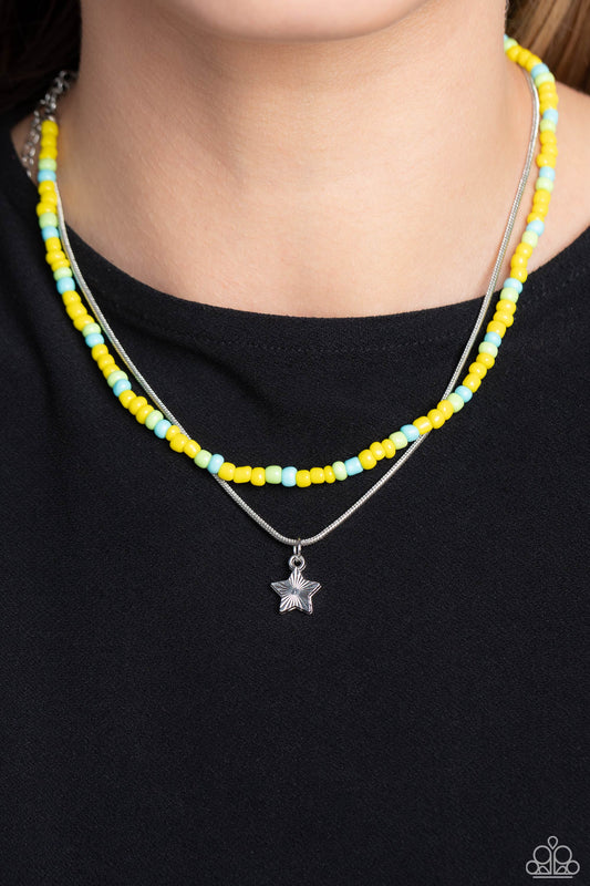 Starry Serendipity Yellow Necklace - Paparazzi Accessories  Multicolored seed beads in shades of yellow, blue, and green are threaded along a wire, falling along the collar in a capricious pattern. A delicate silver snake chain, features a twinkling silver star etched with linear textures, as it layers together with the colorful beads for a sassy and starry, combo. Features an adjustable clasp closure.  Sold as one individual necklace. Includes one pair of matching earrings.  P2DA-YWXX-074XX